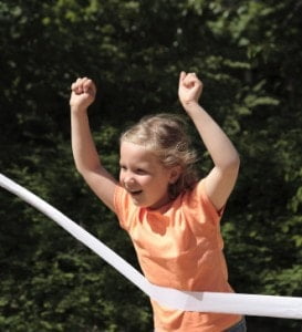 Girl running to winning tape